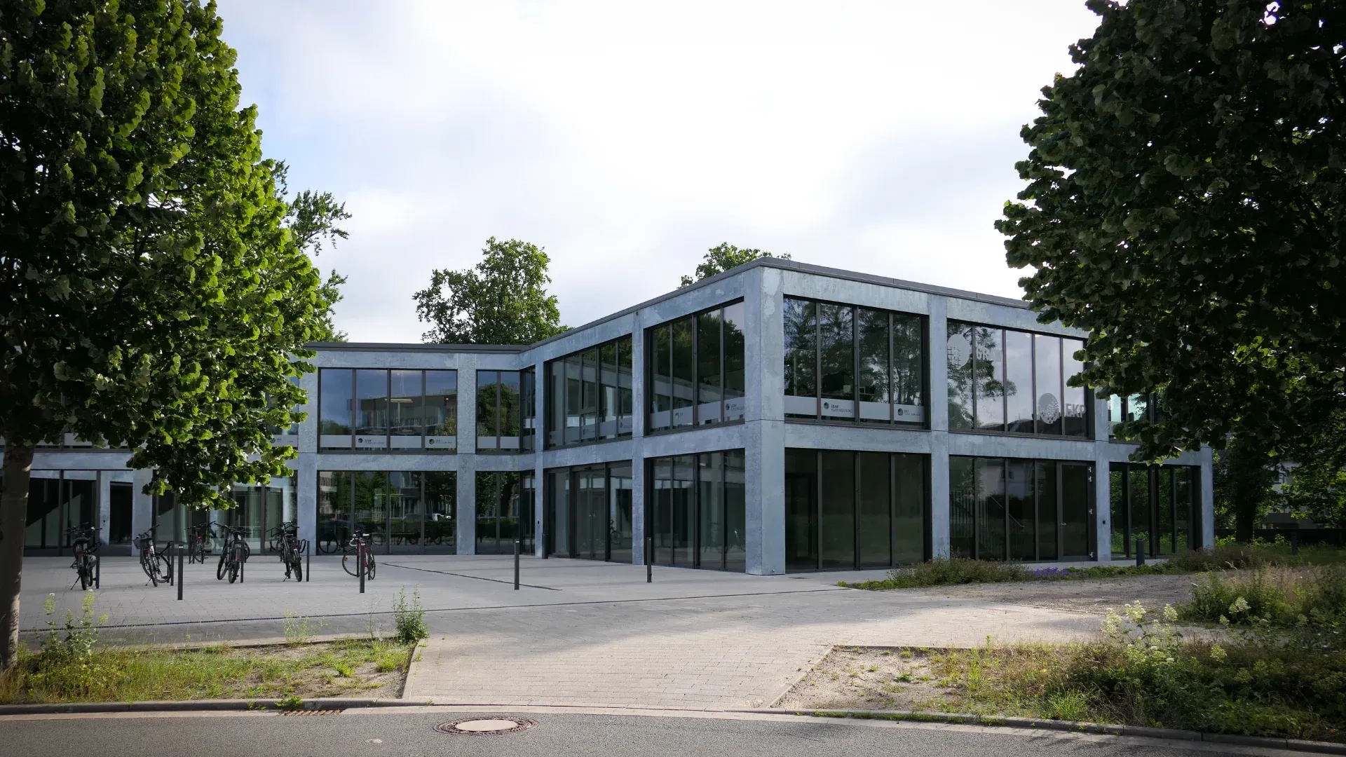 Planungsbüro Graw Osnabrück – modernes nachhaltiges Bürogebäude mit Beton-Glas-Architektur, großer Fensterfront und grüner Umgebung – Spezialist für TGA und energieeffiziente Gebäudetechnik